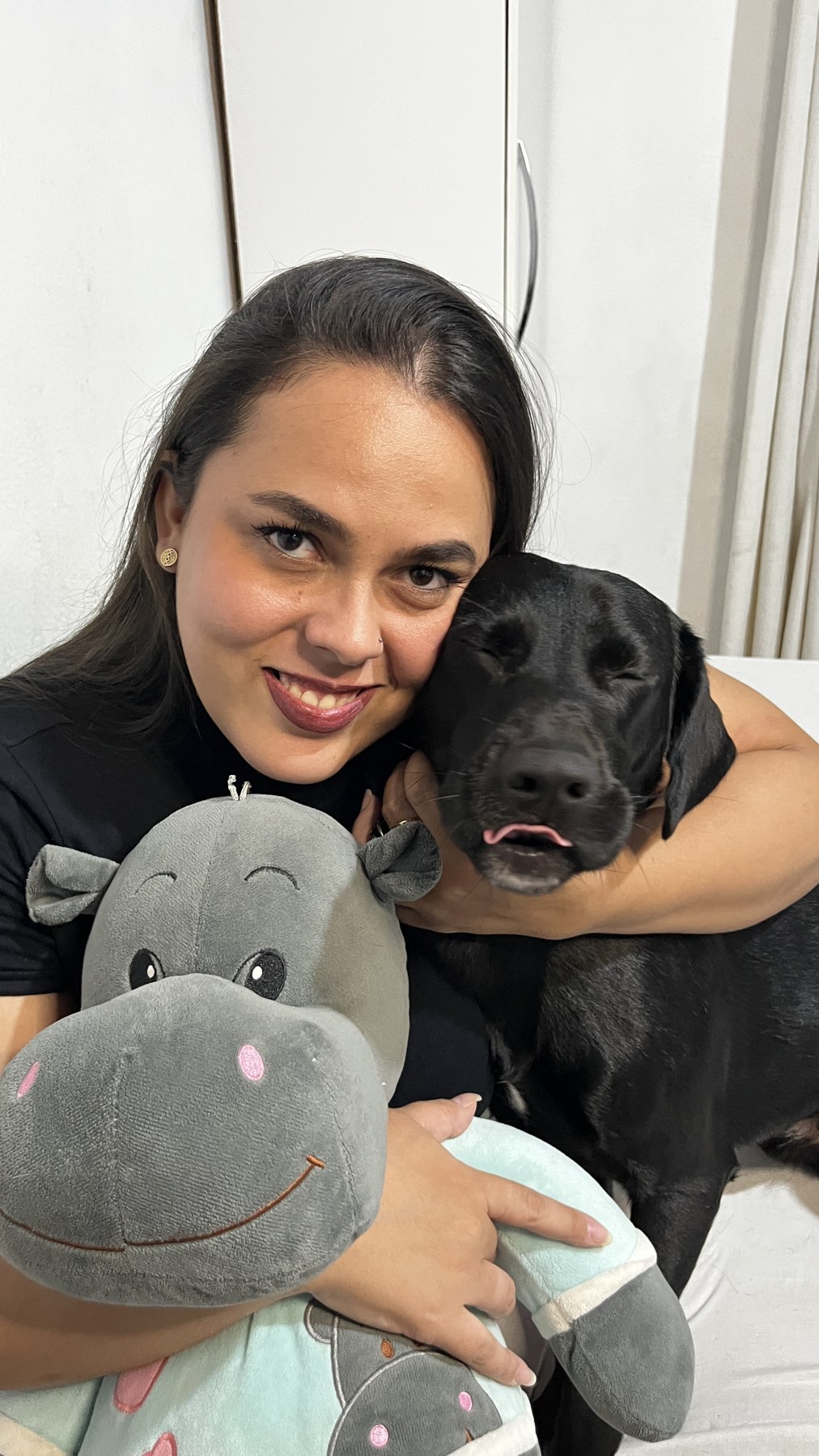 Ingrid abraçada com Sirius e a hipopótama de pelúcia Xura